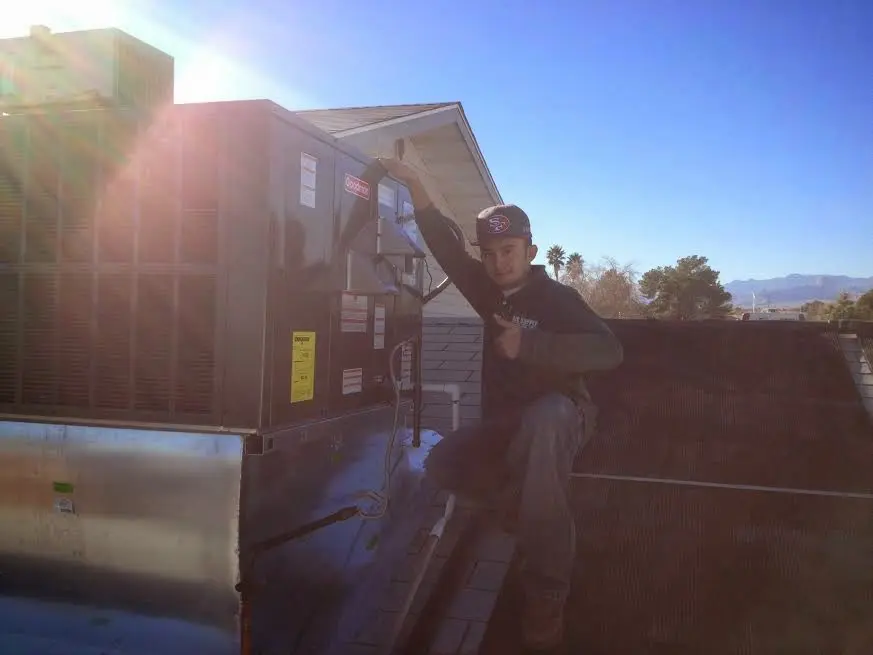 HVAC technician performing Boiler Repair on a rooftop unit in Oakland